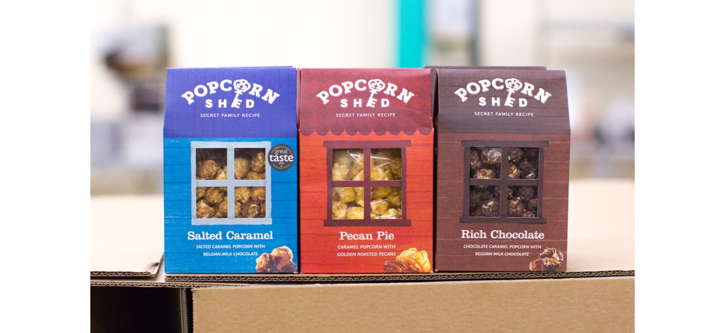 Three Popcorn Shed packages displayed next to each other. Flavours of salted caramel, pecan pie and rich chocolate.